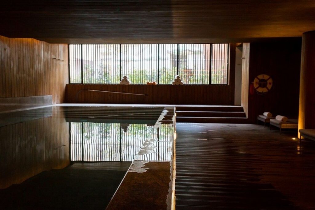 Lugnt hotellspa med träpanel, stilla pool och vilstolar