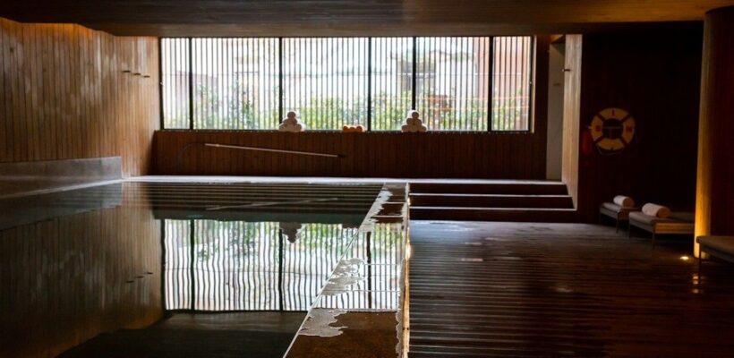 Lugnt hotellspa med träpanel, stilla pool och vilstolar
