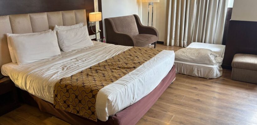 Hotellrum med dubbelsäng, extrasäng och sittgrupp för familjer