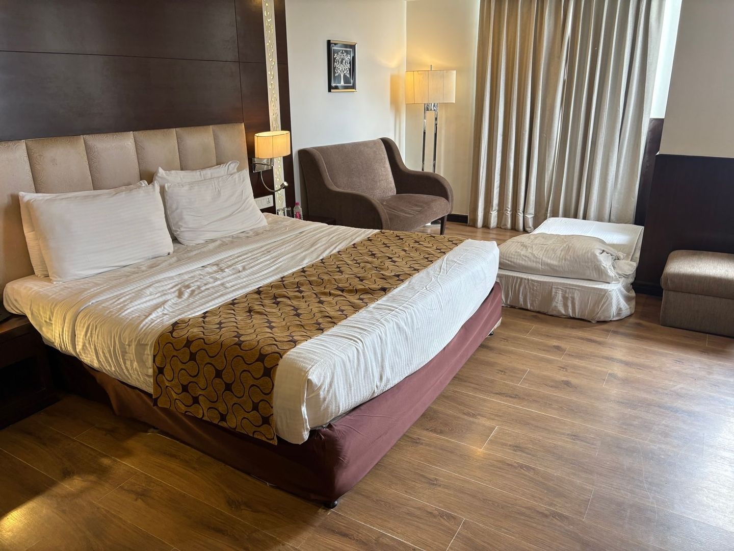 Hotellrum med dubbelsäng, extrasäng och sittgrupp för familjer